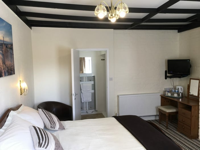 Room 10: ground-floor room with a standard double bed and en-suite shower, next to the courtyard car park